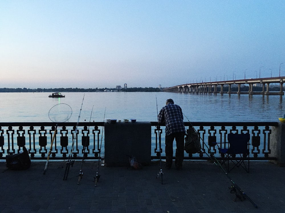 homme en veste noire debout sur le quai pendant la journée