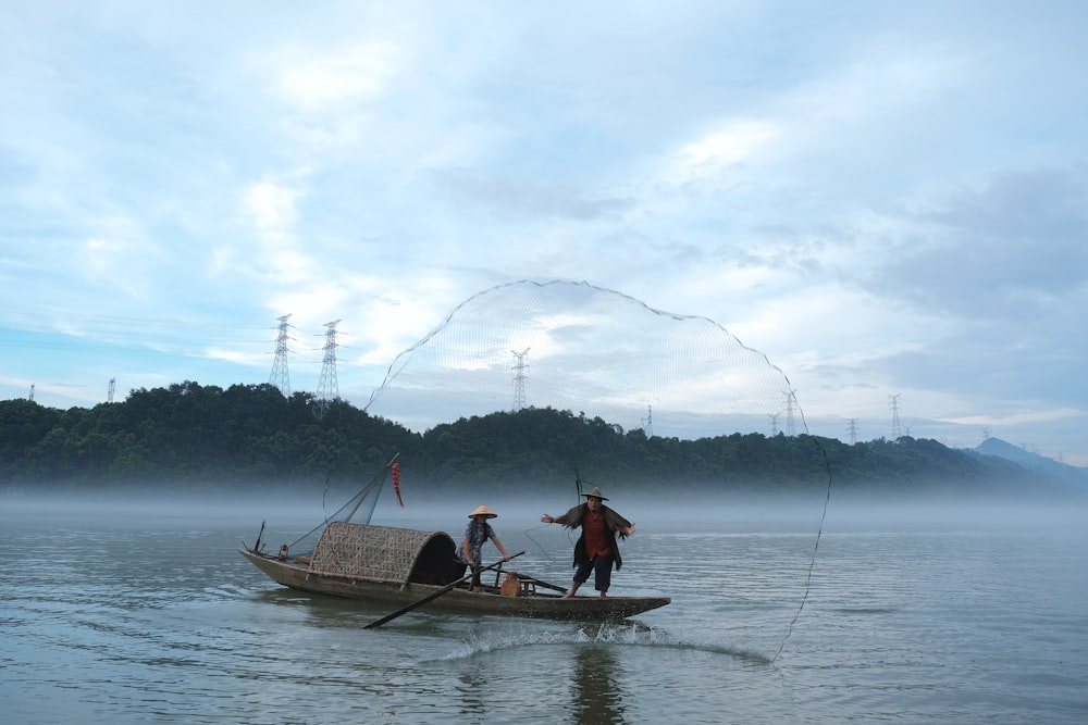 2 men riding on boat on sea during daytime