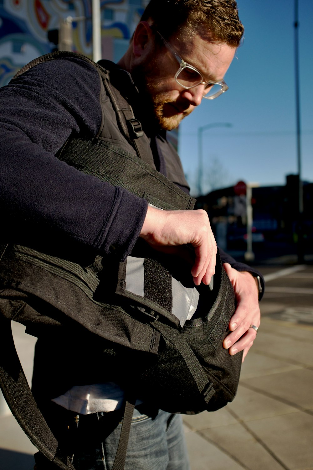 Mann in schwarzer Jacke und schwarzem Rucksack