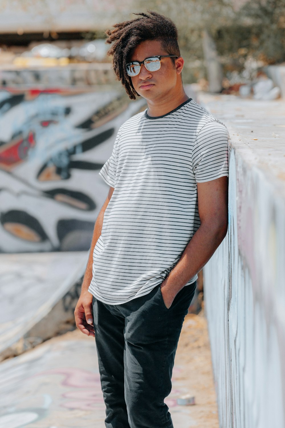 man in white and black striped crew neck t-shirt and black denim jeans standing on on near on near