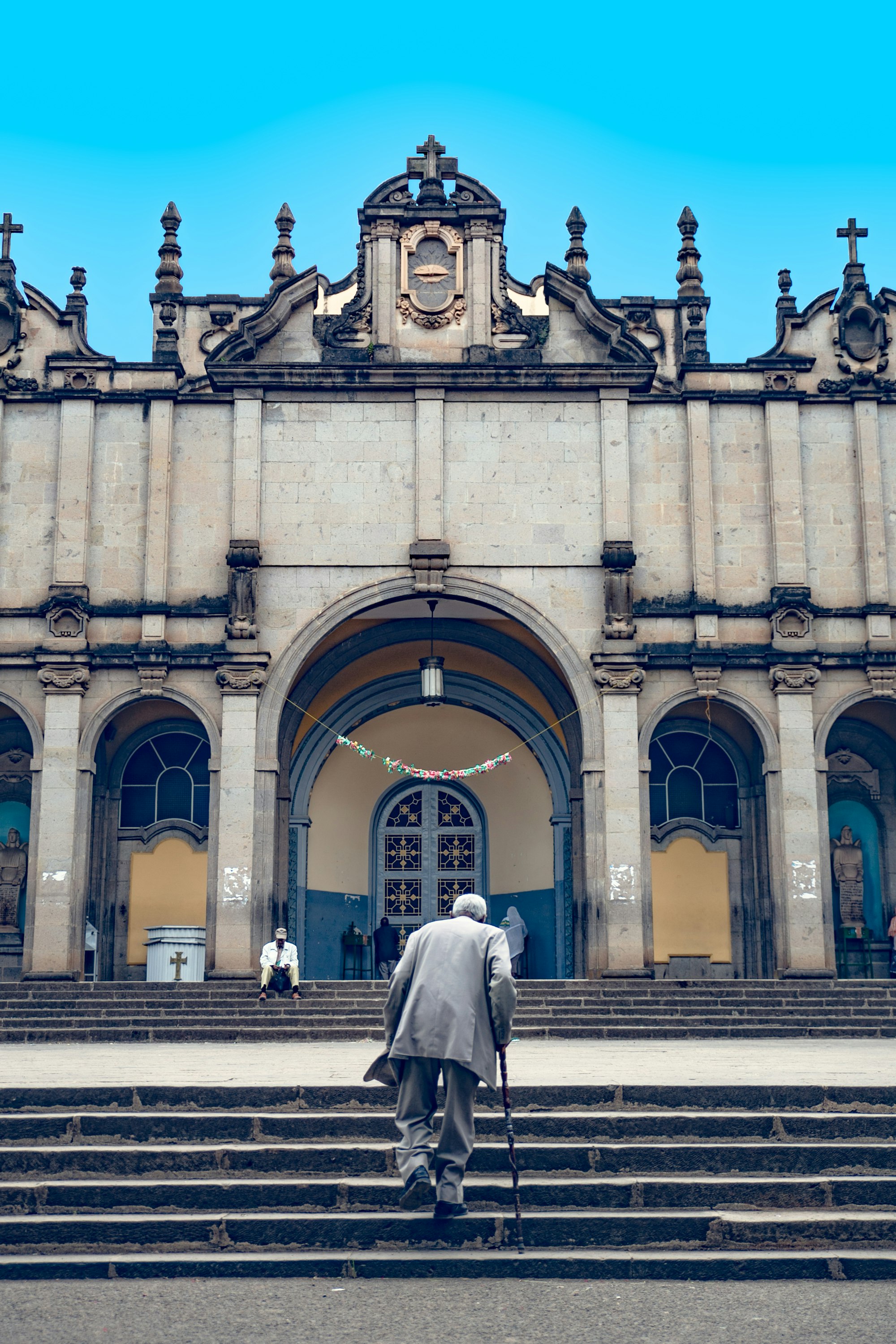 woman in white long sleeve dress walking on sidewalk near building during daytime