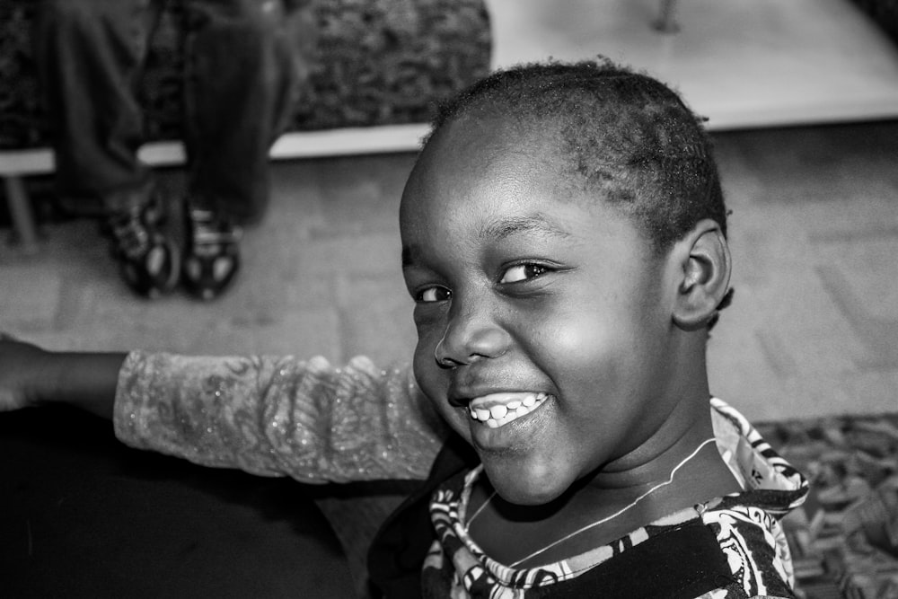 grayscale photo of boy smiling