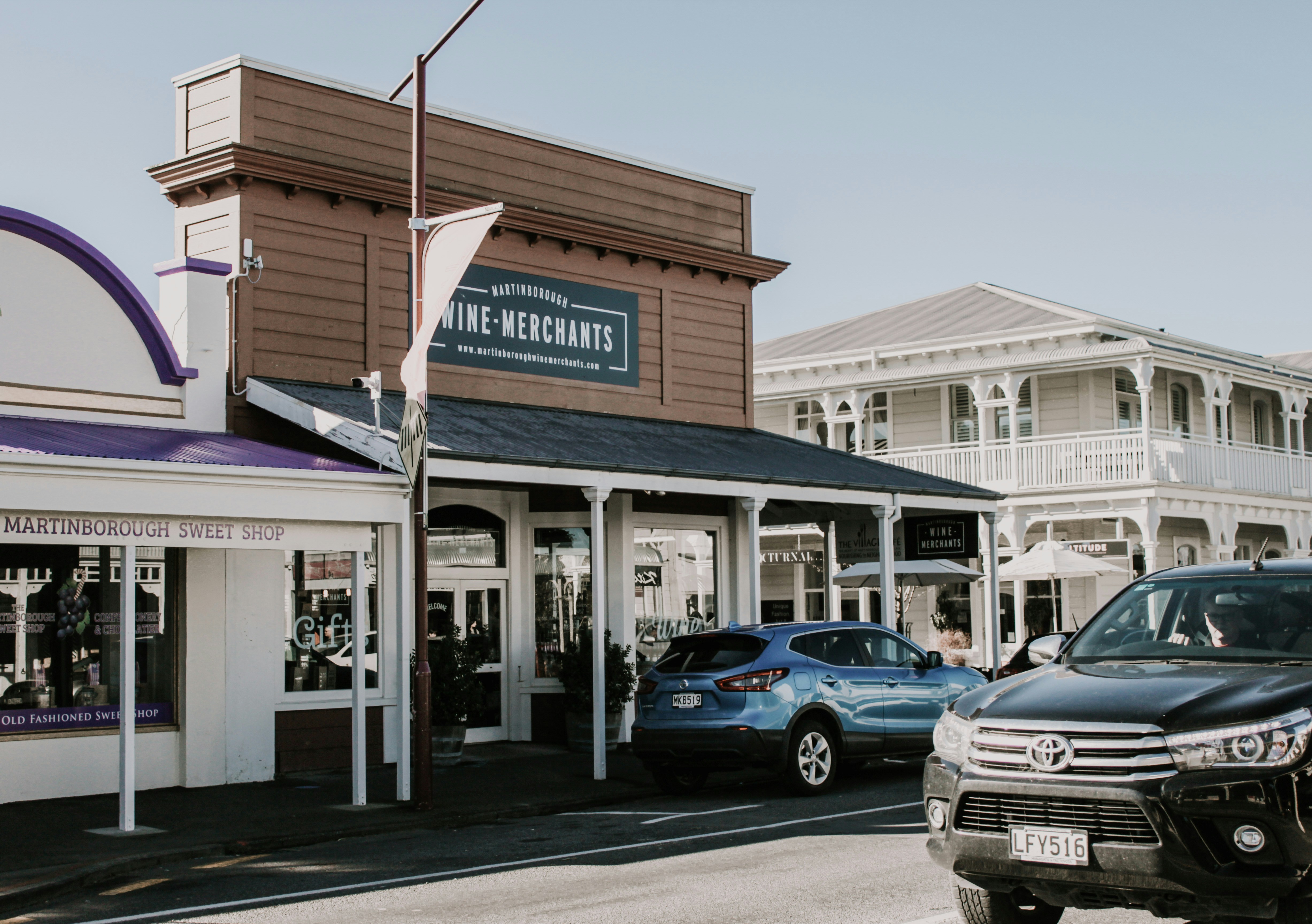 blue car parked beside white building during daytime, Martinborough wine village 