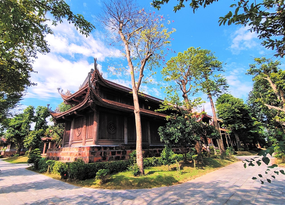 brown wooden house near green trees under blue sky during daytime