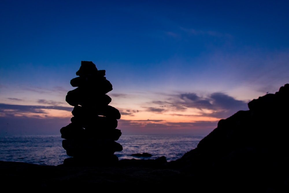 Formación de rocas grises cerca del cuerpo de agua durante el día