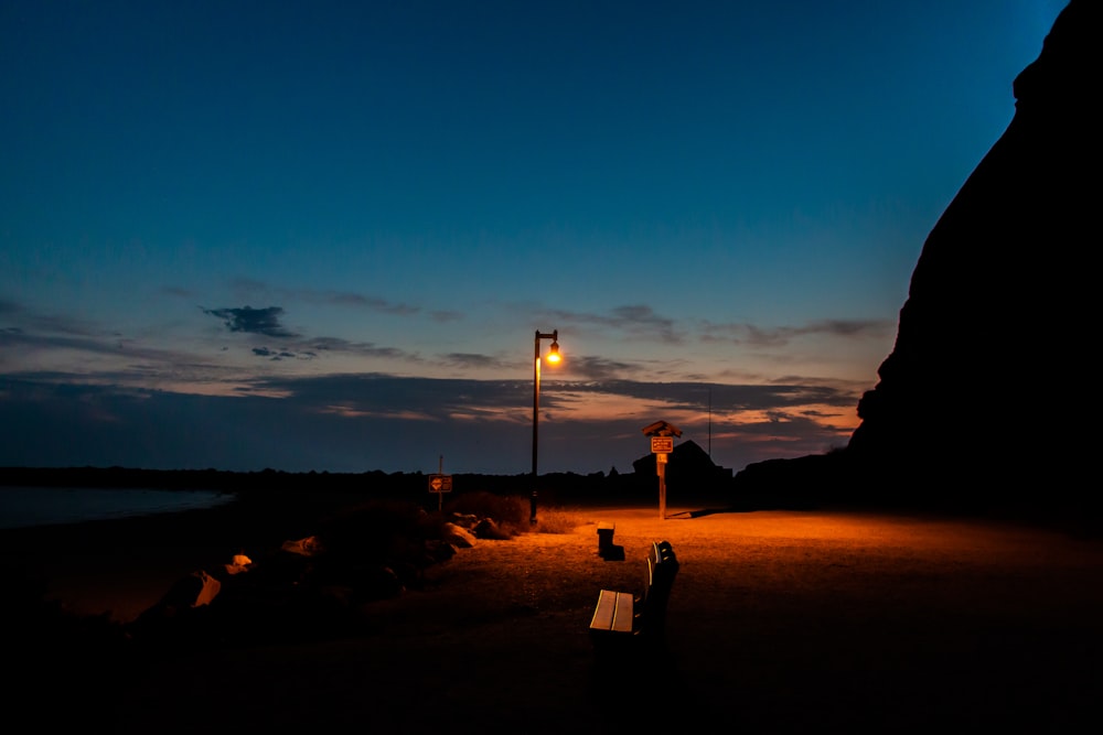 Silueta de la persona de pie en la playa durante la puesta del sol