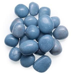 Smooth tumble stones in various shades of blue and green displayed on white fabric.