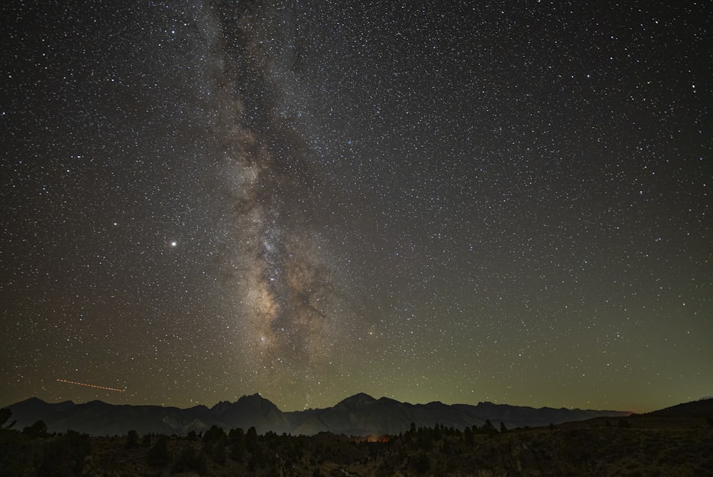 silhouette of mountain under starry night