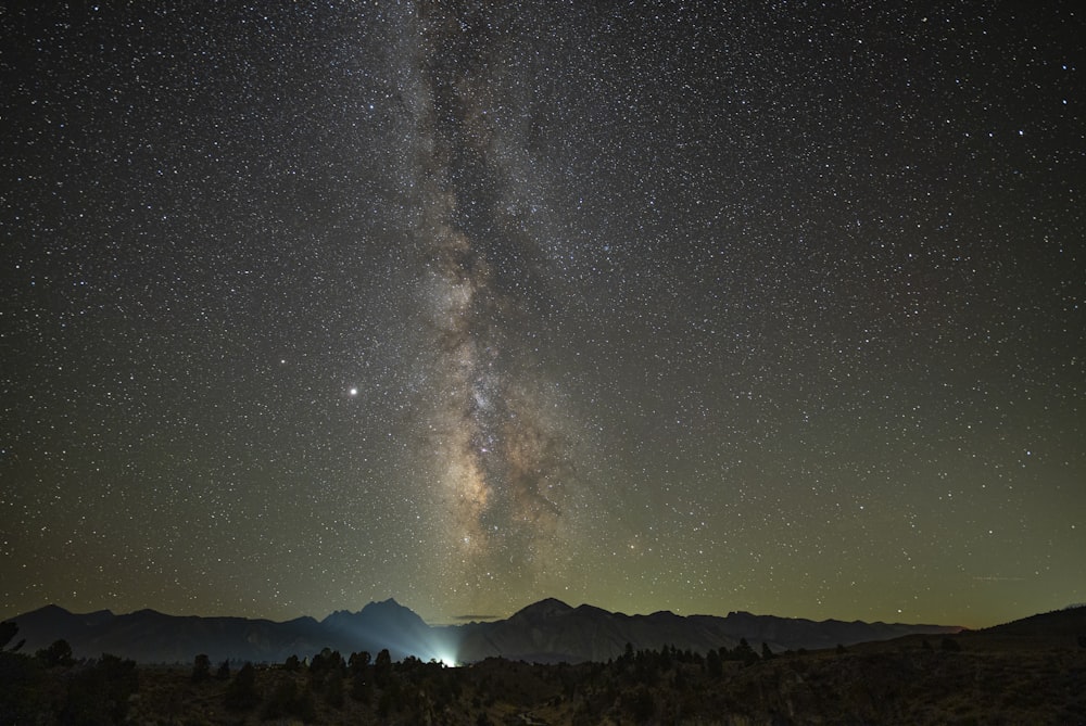 silhouette of mountain under starry night