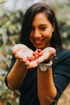 woman holding red round fruits