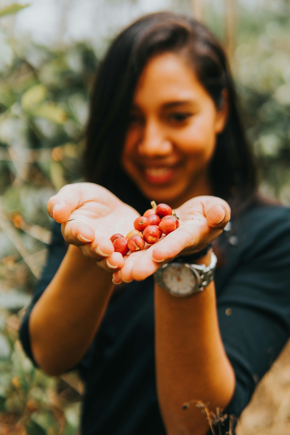 woman holding red round fruits
