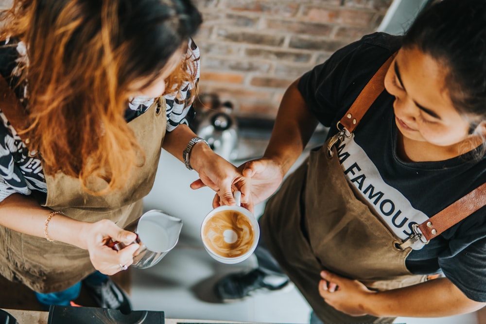 woman in brown t-shirt holding white ceramic mug