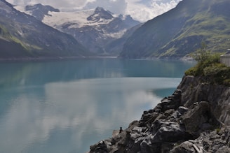 lake near mountain range under blue sky during daytime