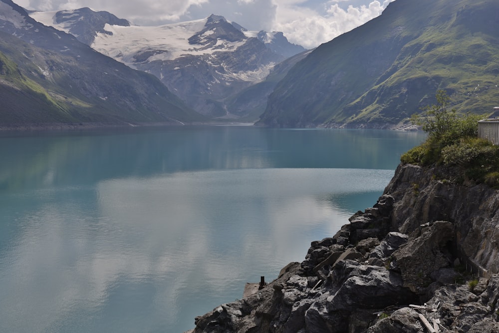 Lago vicino alla catena montuosa sotto il cielo blu durante il giorno