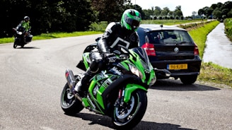 man in green and black motorcycle suit riding on green and black sports bike