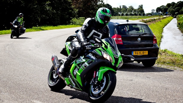 man in green and black motorcycle suit riding on green and black sports bike