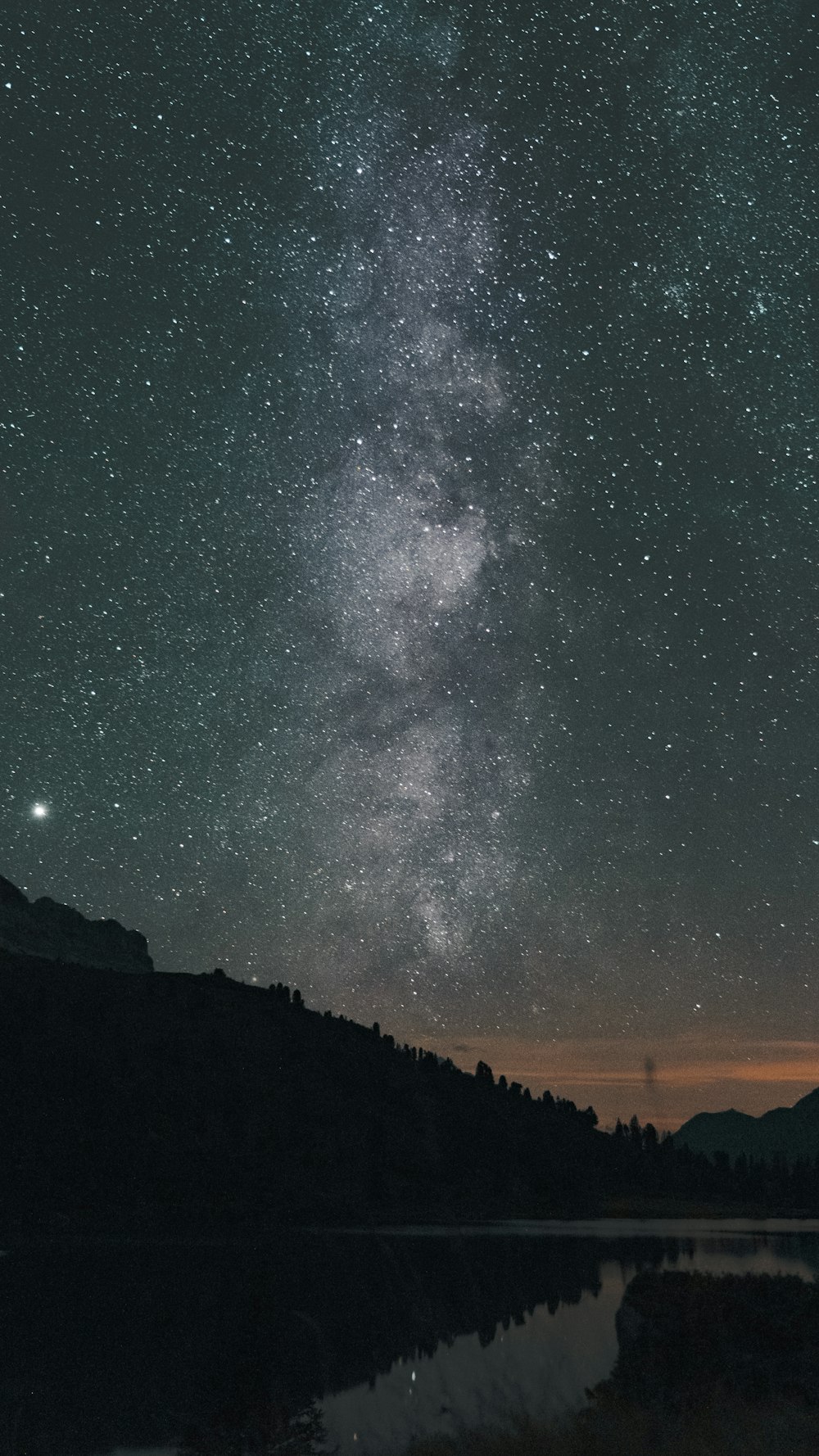 silhouette of mountain under starry night