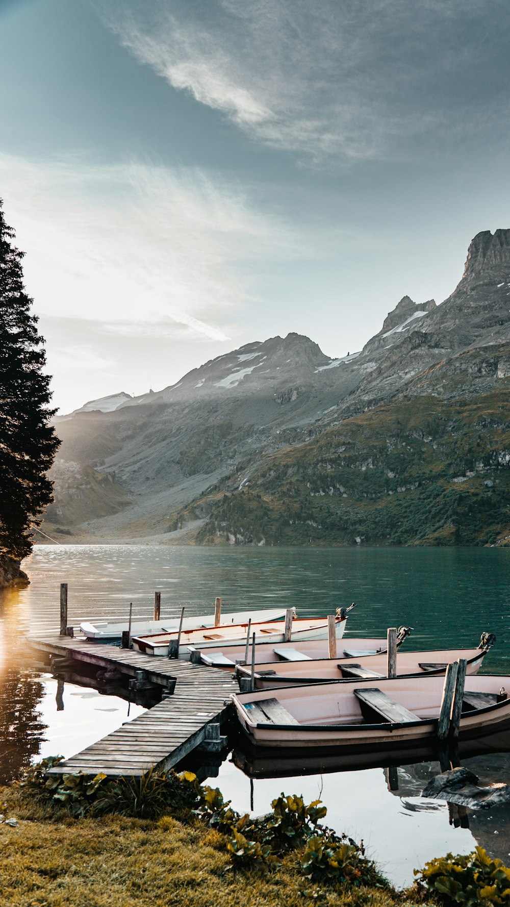 brown wooden dock on lake near mountain during daytime