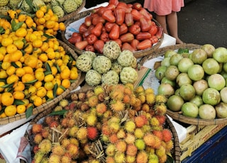 woman in pink long sleeve shirt standing beside fruits