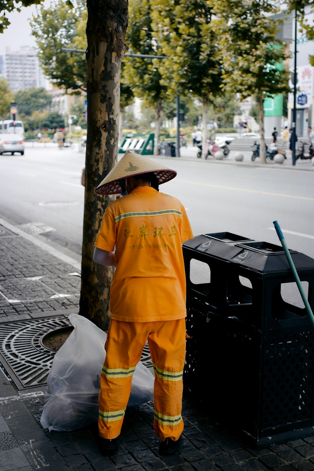 man in yellow and white robe standing on sidewalk during daytime