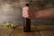 A happy customer holding a cold craft beer bottle with a rustic wooden background.