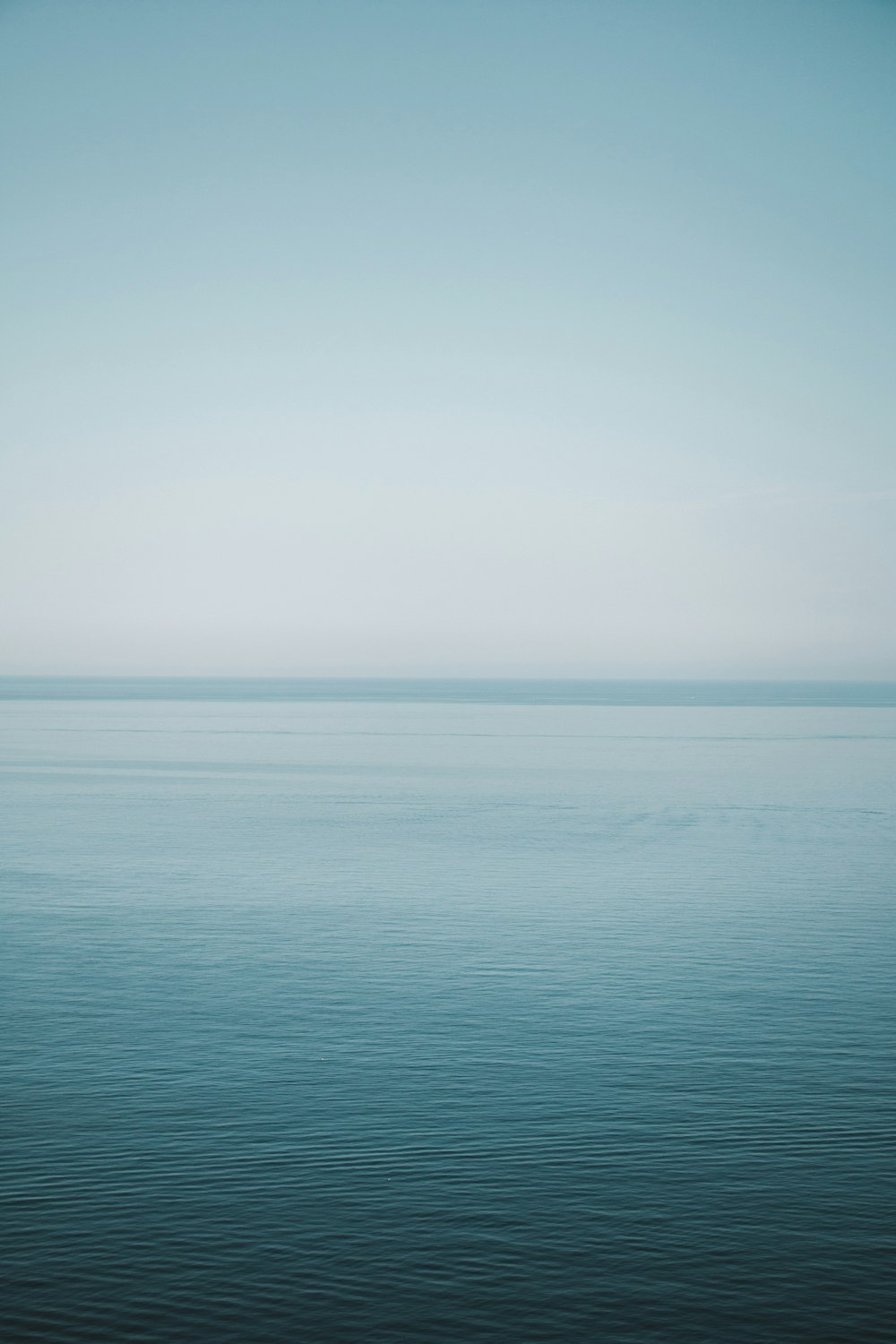 mer bleue sous le ciel blanc pendant la journée