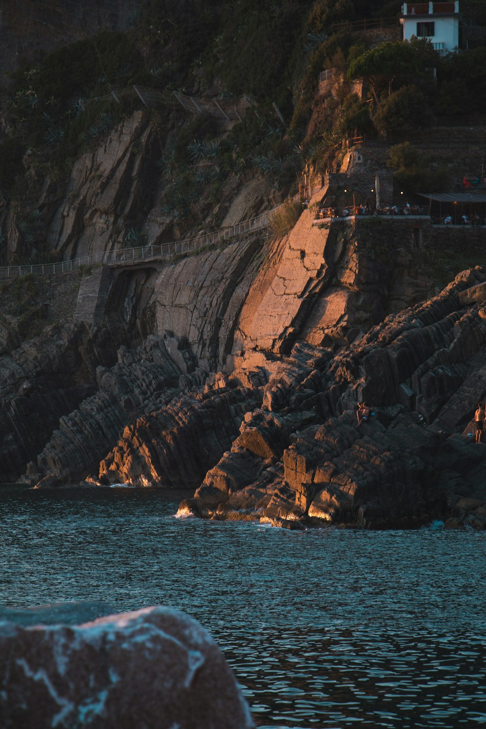 Montaña rocosa marrón junto al mar azul durante el día