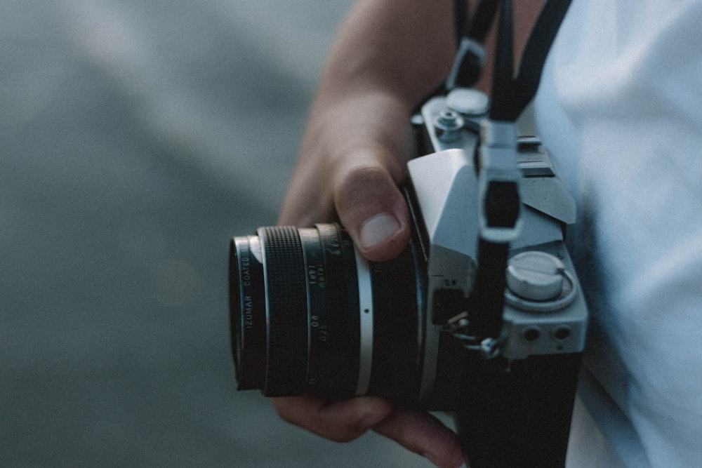 person holding black and silver dslr camera