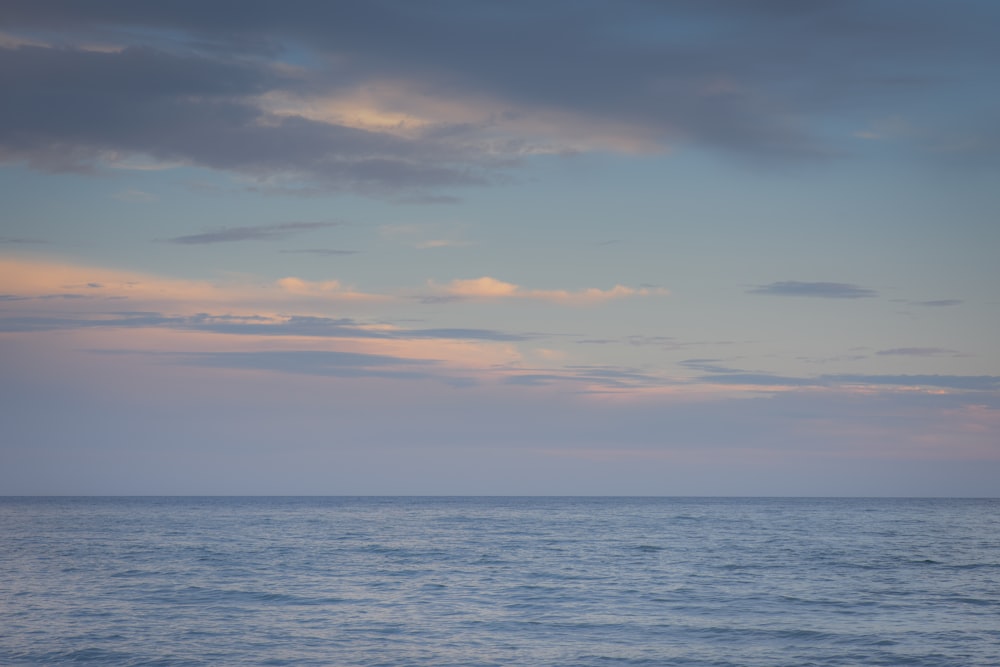 specchio d'acqua sotto il cielo nuvoloso durante il giorno