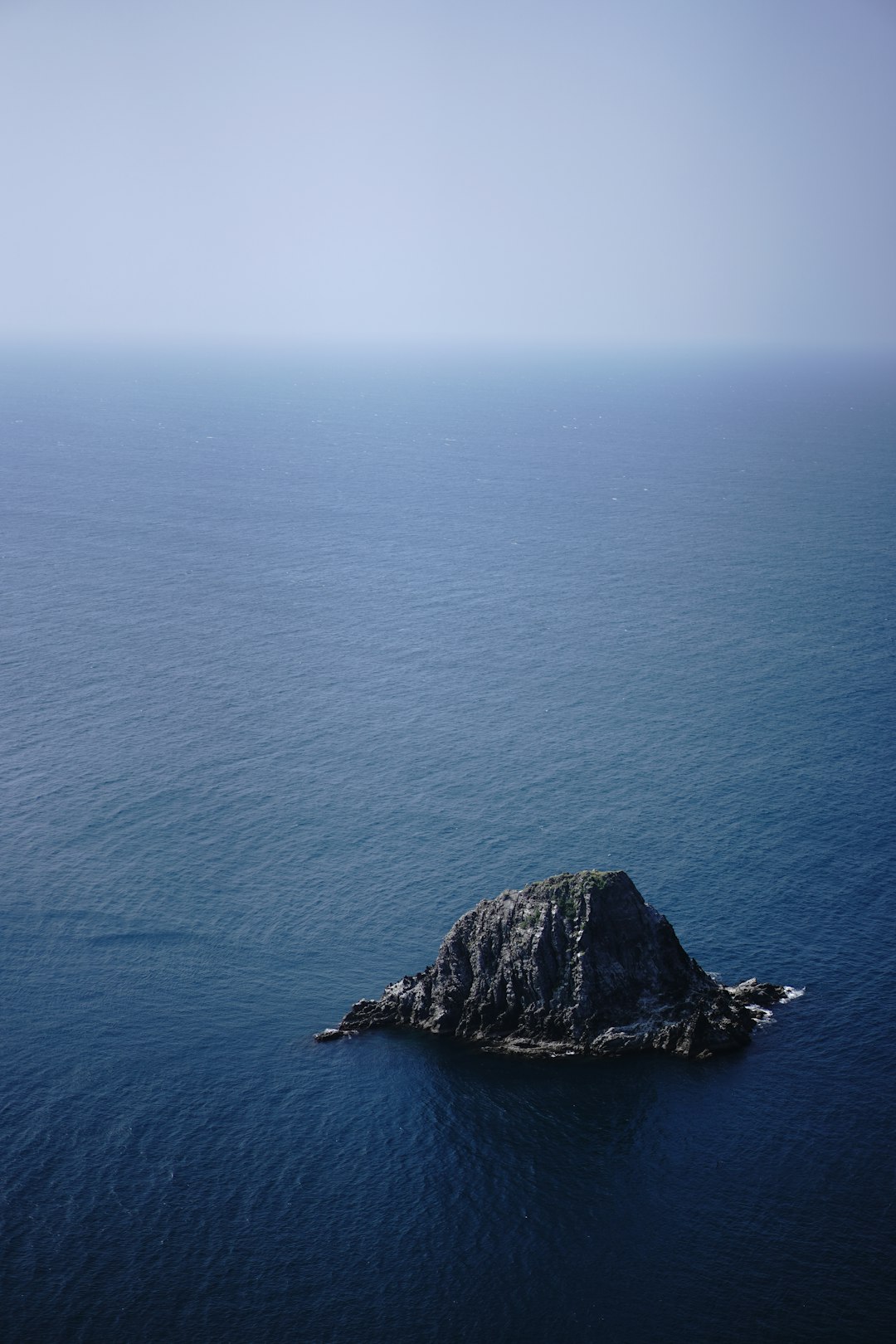 black rock formation on blue sea during daytime