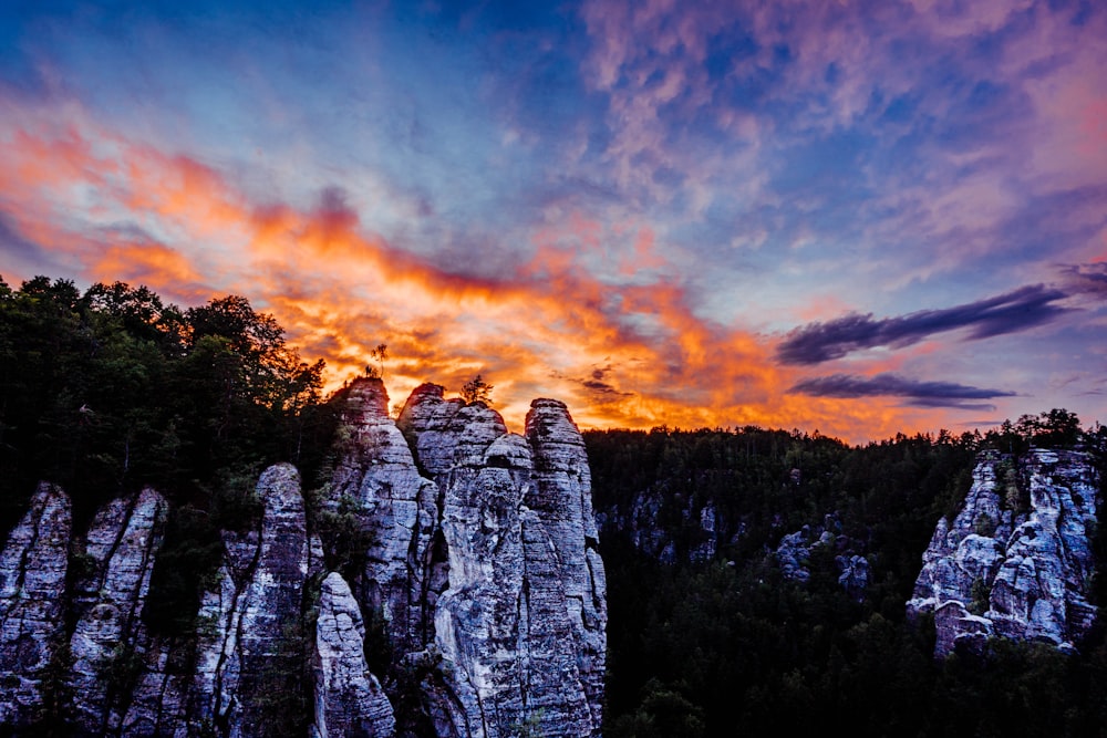 gray rock formation under orange and blue sky