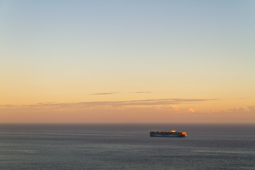 blue and orange boat on sea during daytime