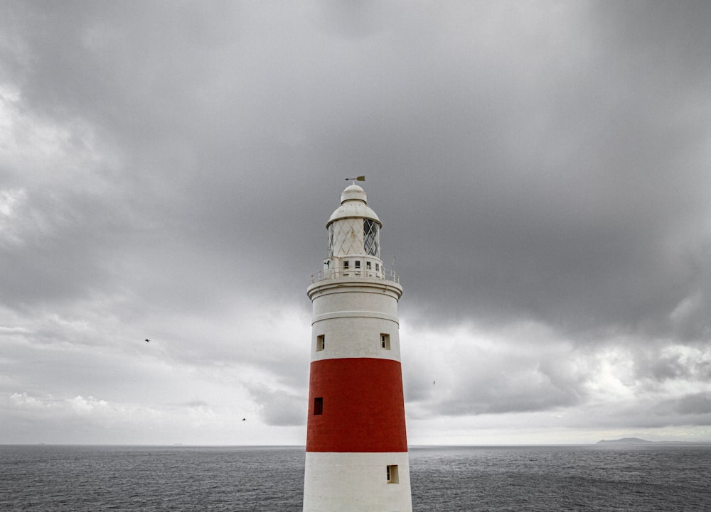 red and white lighthouse under cloudy sky during daytime