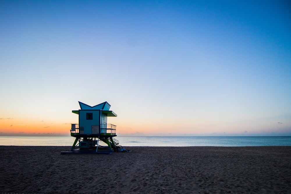 blue wooden lifeguard house on beach shore during daytime