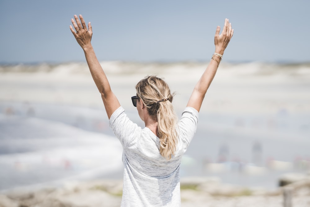 woman in white long sleeve shirt raising her hands