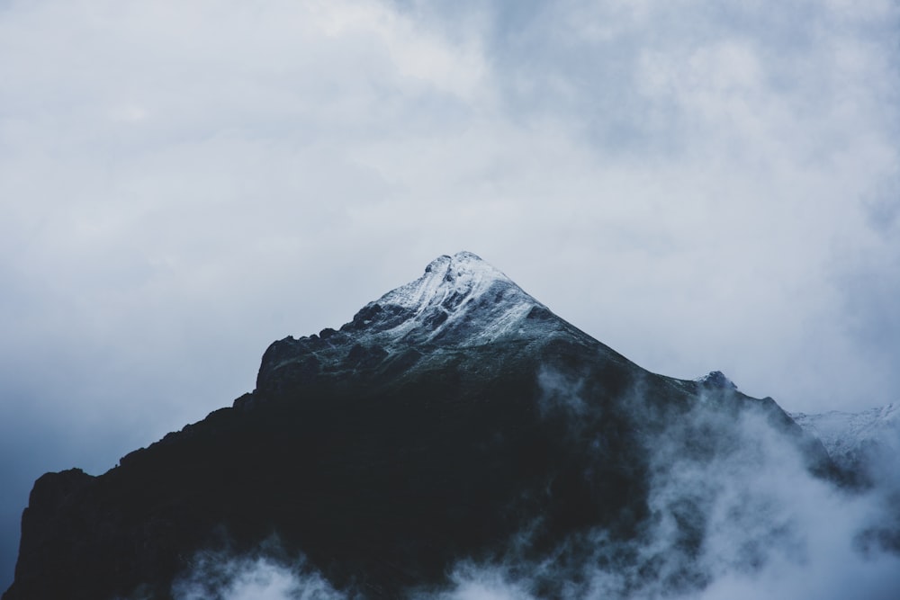 snow covered mountain under cloudy sky during daytime