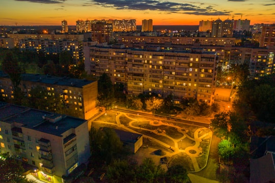 Aerial view of a thoughtfully designed city park surrounded by modern buildings at sunset.