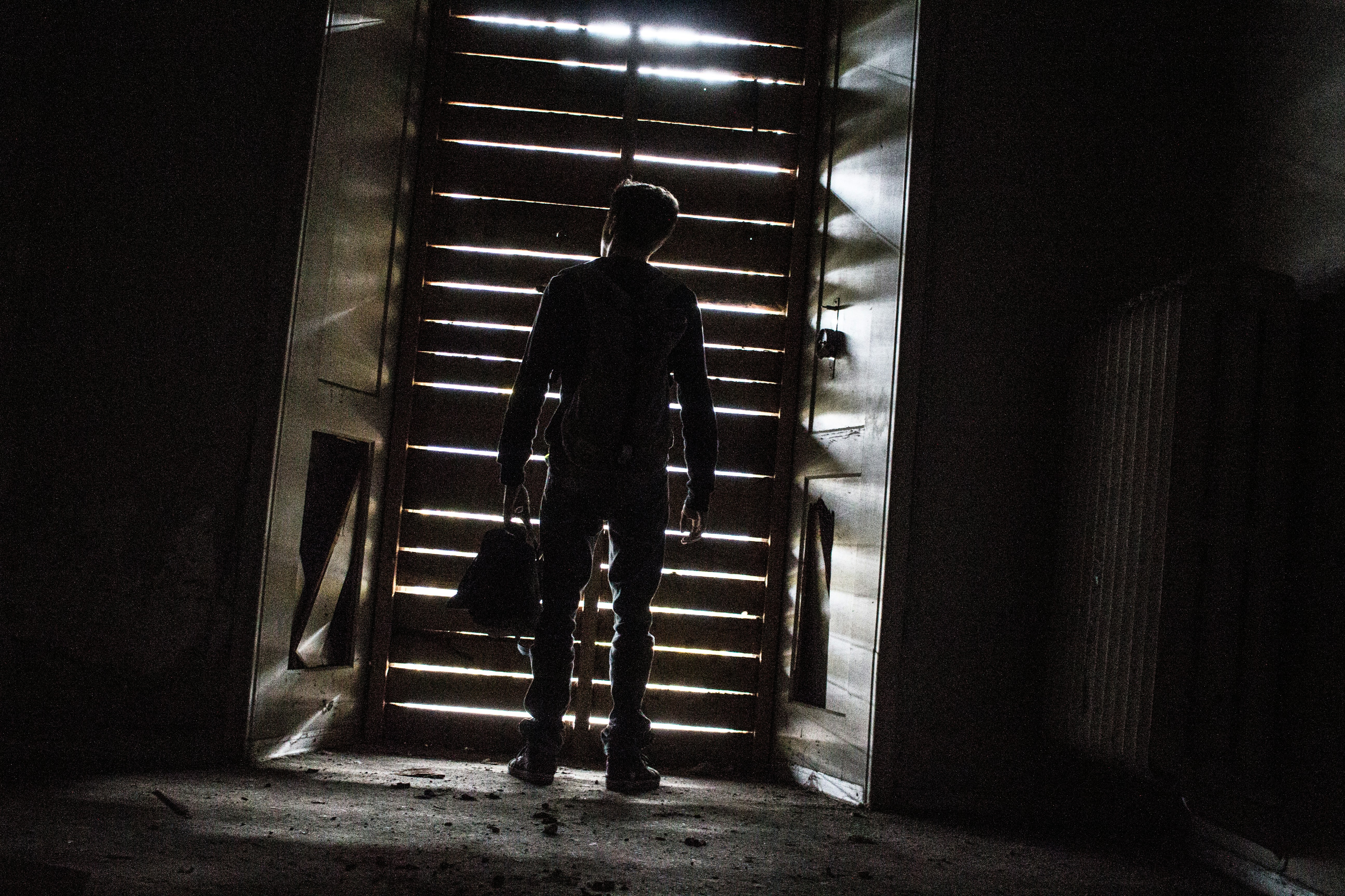 man in black jacket standing on hallway (Photo by Mike Bravo on Unsplash)