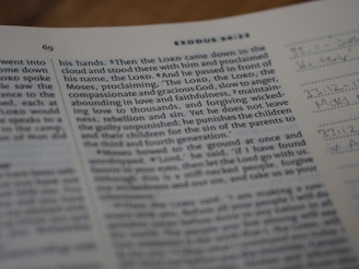 A close-up of an open book, focusing on a passage featuring a religious text. The page number is 69, and 'Exodus 34:13' is visible at the top. Handwritten notes are present on the right margin of the page.