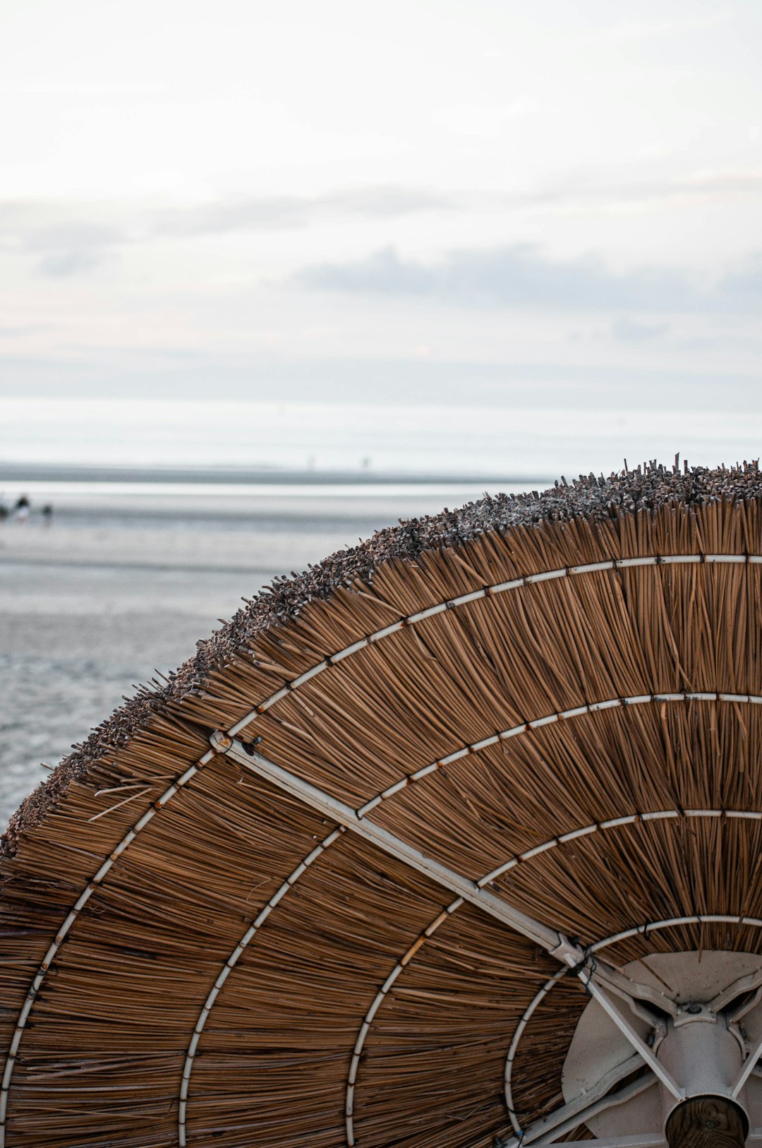 brown woven umbrella near sea during daytime