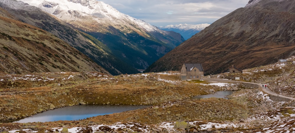 white and brown house near lake and mountains during daytime