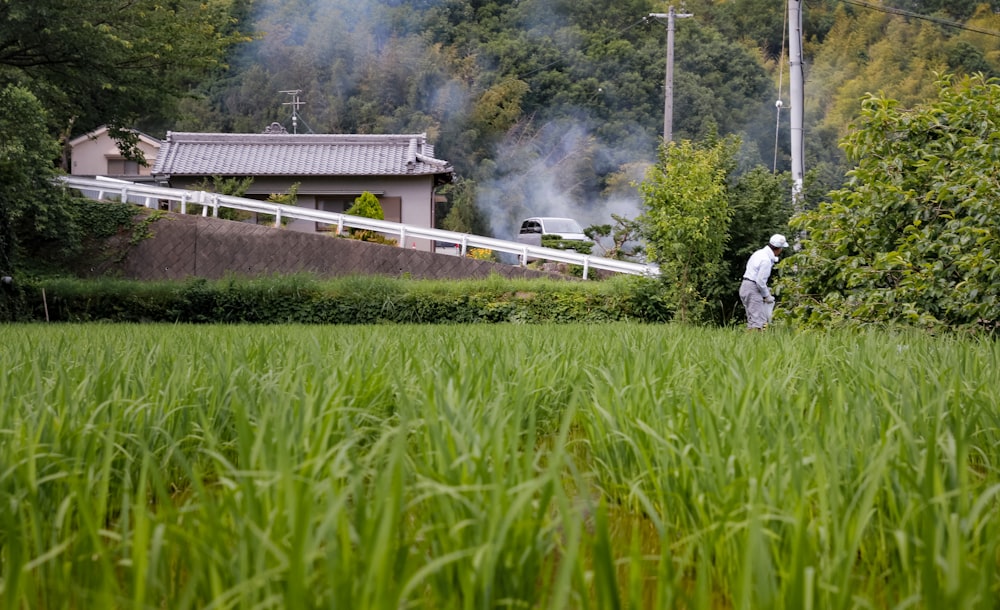 man in white shirt walking on green grass field during daytime