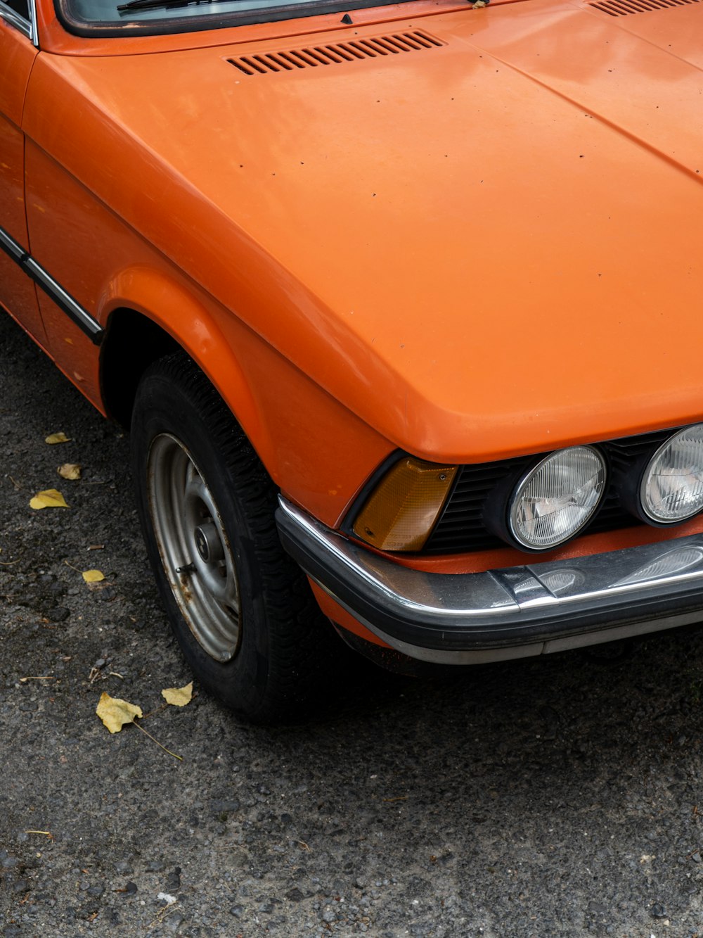 orange car on gray concrete pavement