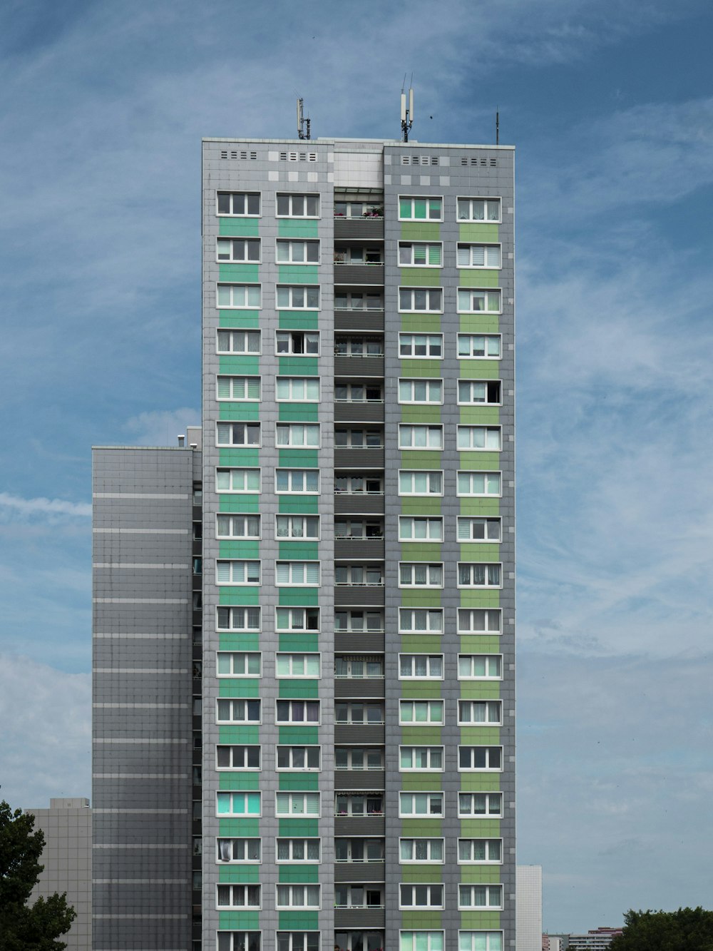 Edificio de hormigón blanco y azul bajo el cielo azul durante el día