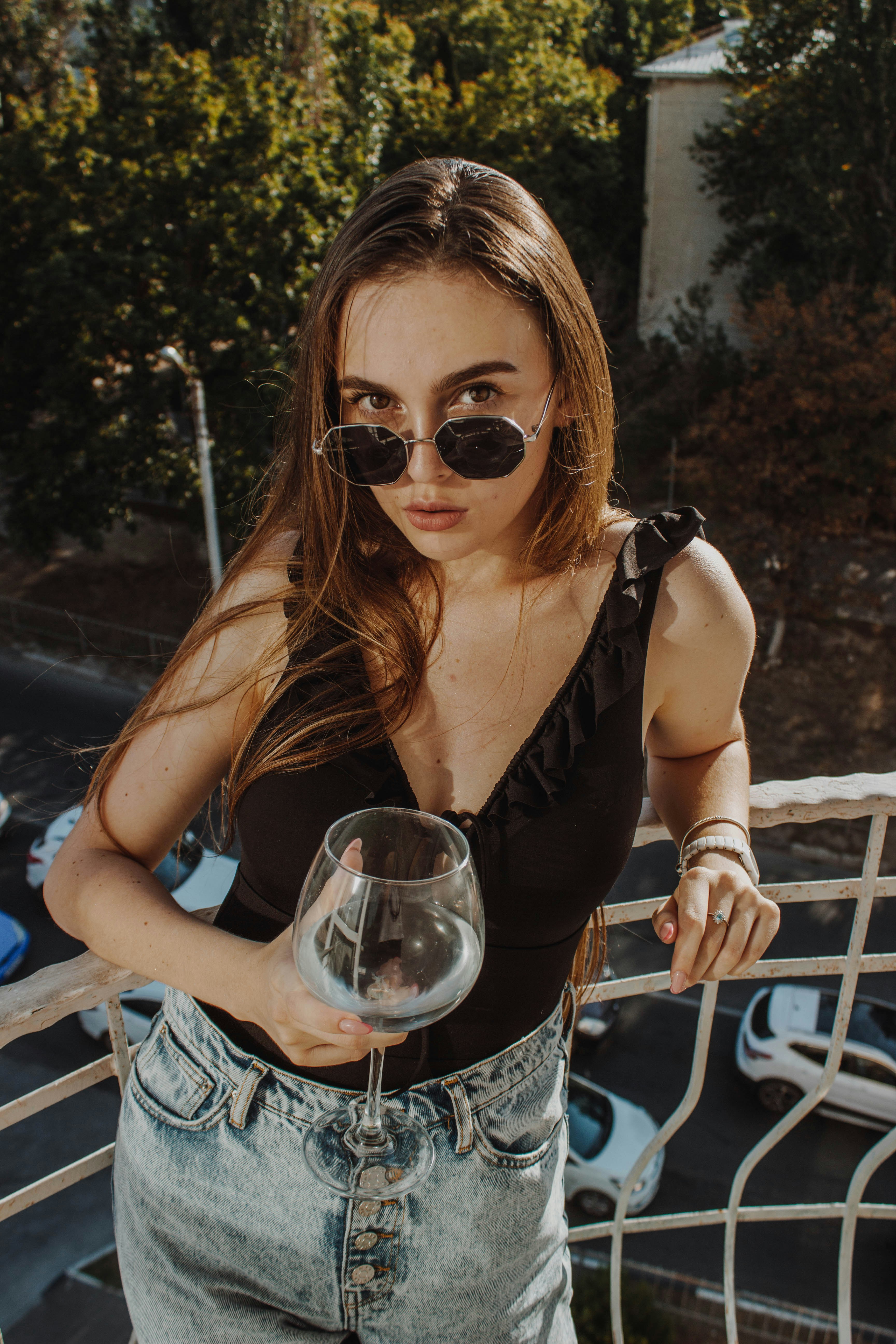 woman in black tank top wearing sunglasses holding wine glass