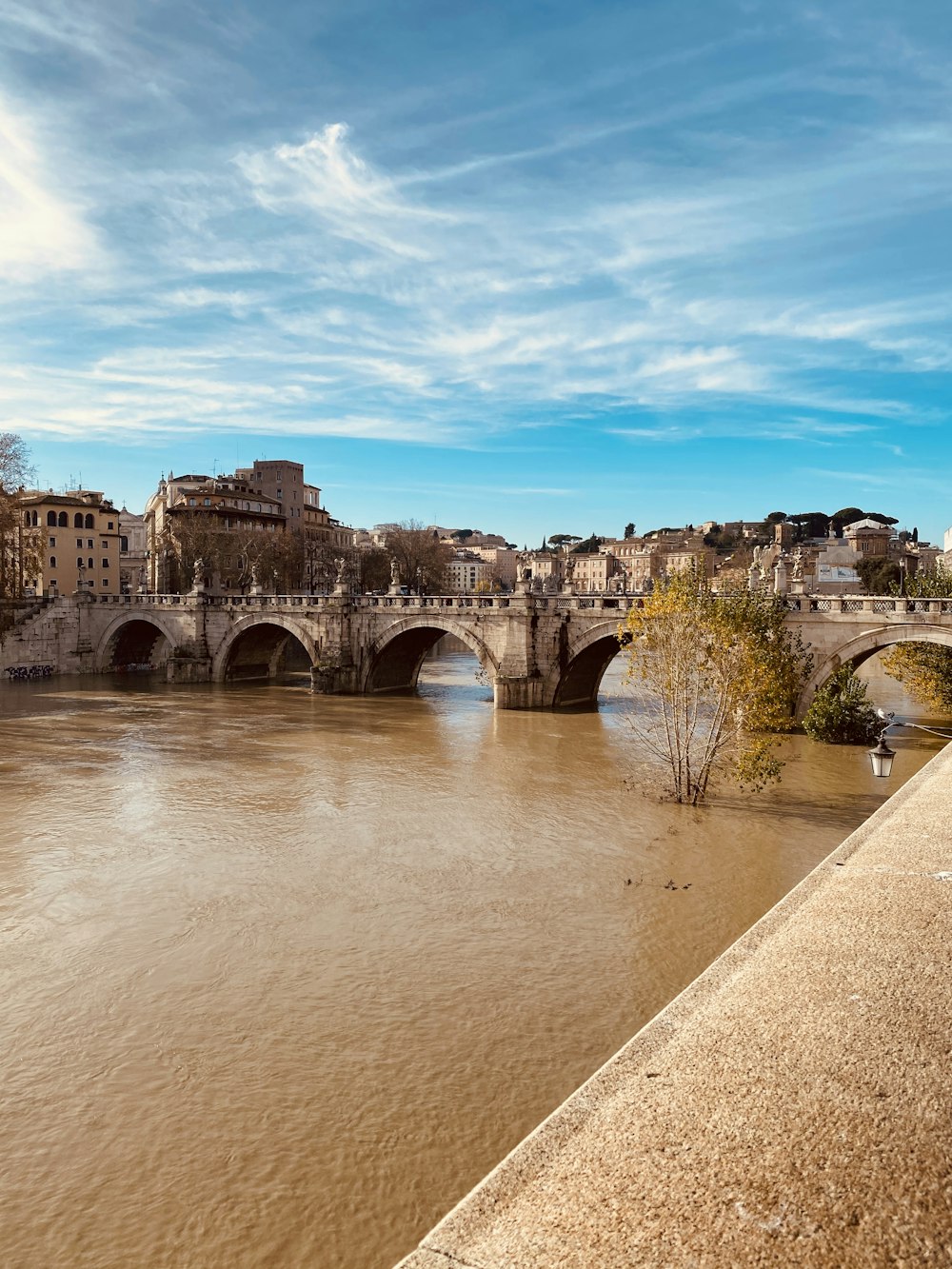 Braune Betonbrücke über den Fluss unter blauem Himmel tagsüber