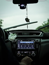 A person enjoying music in a car with a satellite radio receiver visible.