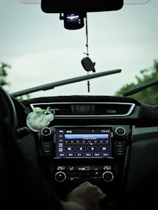 A person enjoying music in a car with a satellite radio receiver visible.