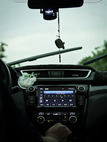 A happy family enjoying music together in their car, the SRS FM radio screen visible on the dashboard.