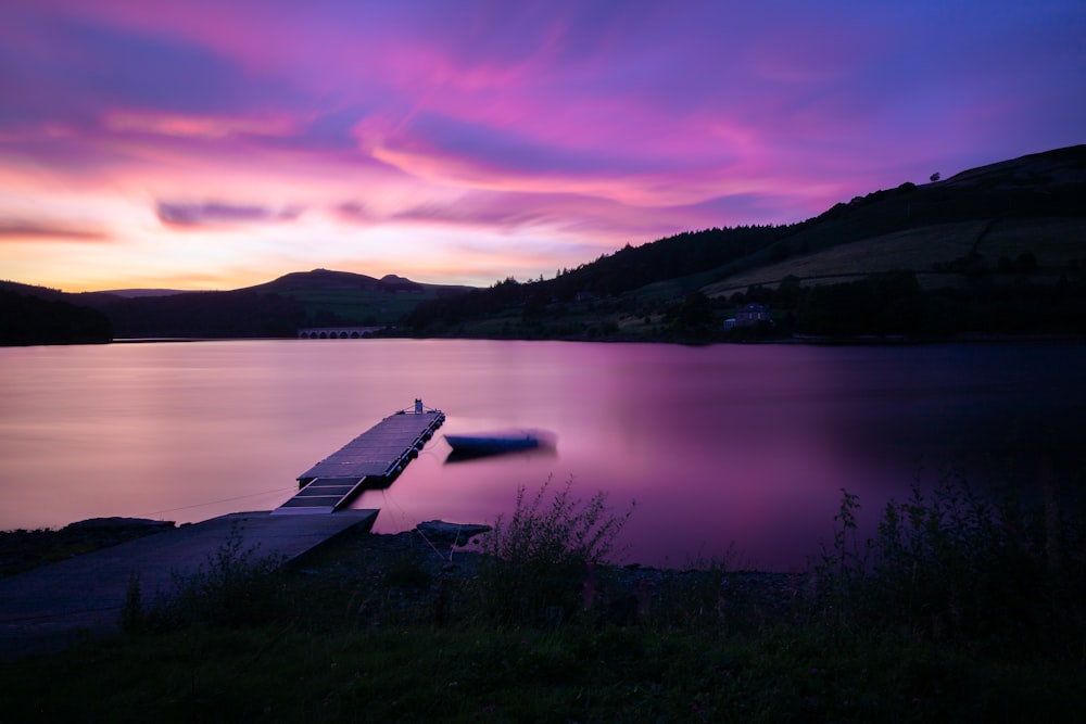 white wooden dock on lake during sunset